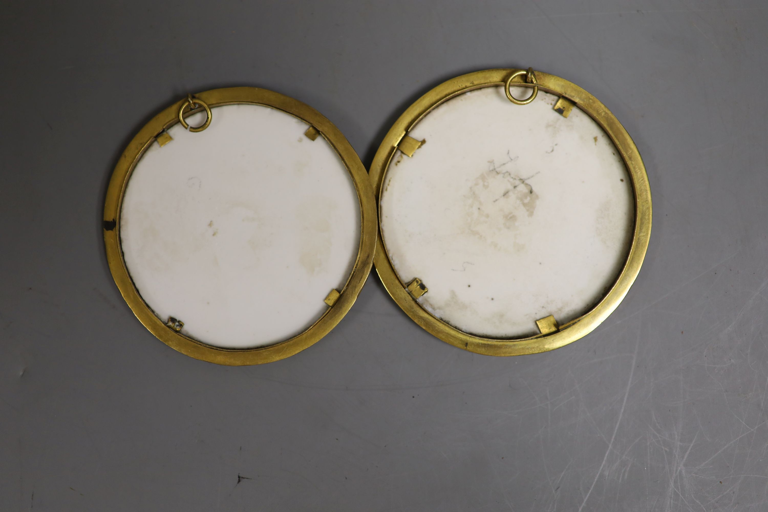 A pair of 19th century German porcelain circular portrait plaques, 7cm diameter